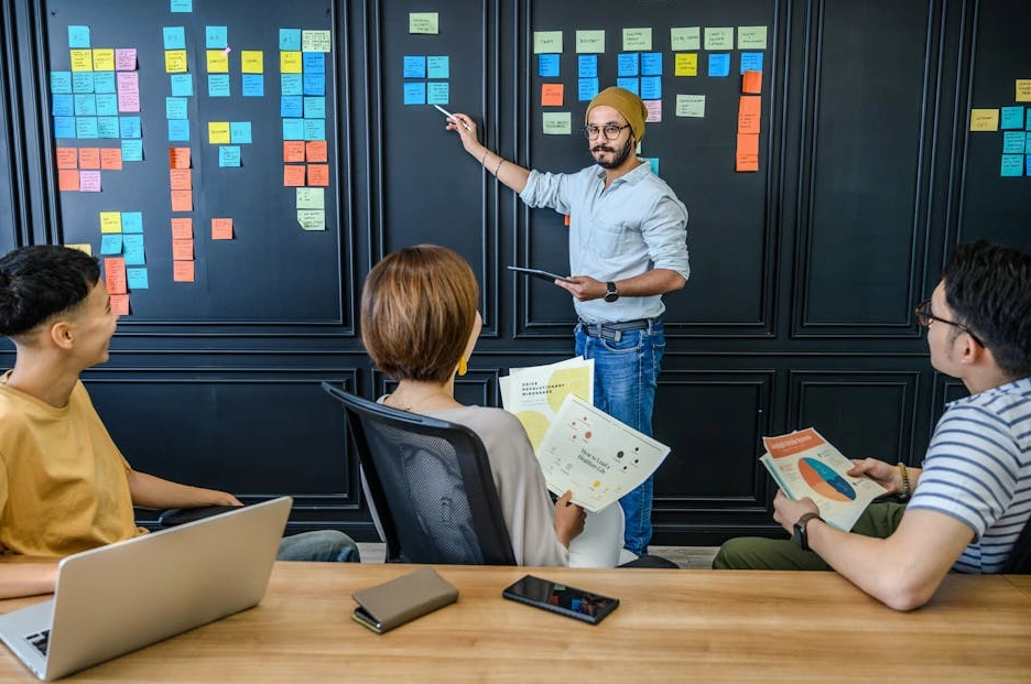 Grupa kreatywna omawiająca plan treści na tablicy.